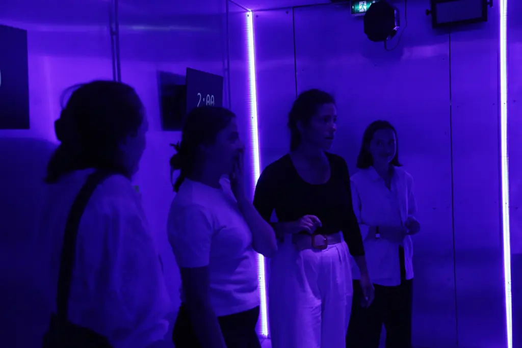 Personnes discutant dans une pièce éclairée en violet.