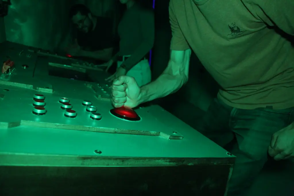 Personne appuyant sur un gros bouton rouge lumineux.