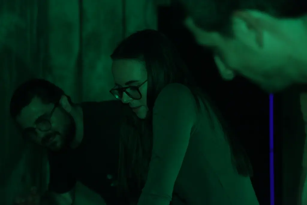 Groupe de personnes éclairées par une lumière verte.