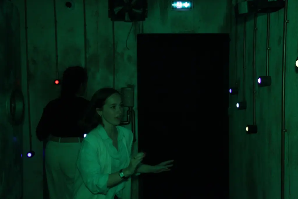 Personnes explorant une pièce sombre et mystérieuse.