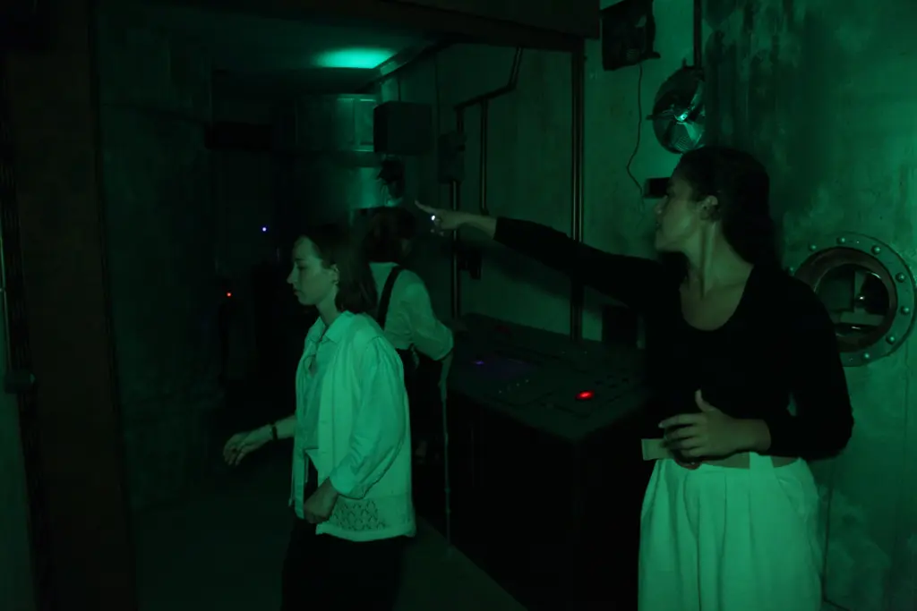 Personnes dans une pièce sombre avec lumière verte.