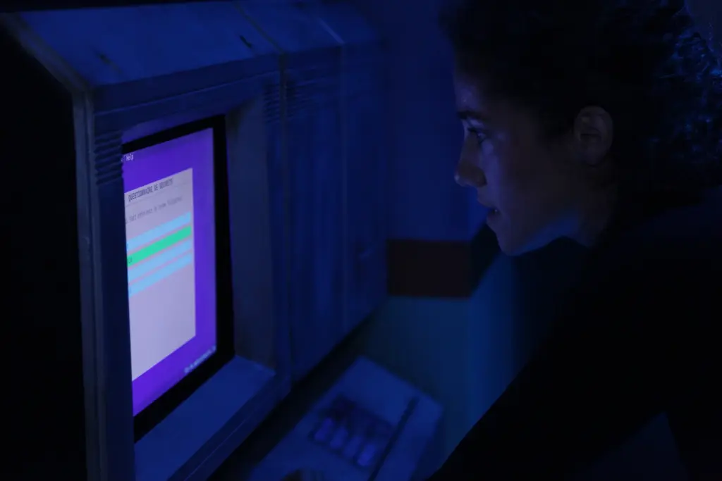 Personne regardant un écran d'ordinateur la nuit.