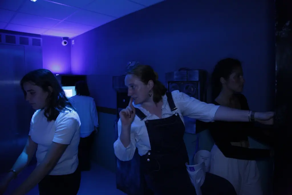 Personnes dans une salle violette, ambiance mystérieuse.