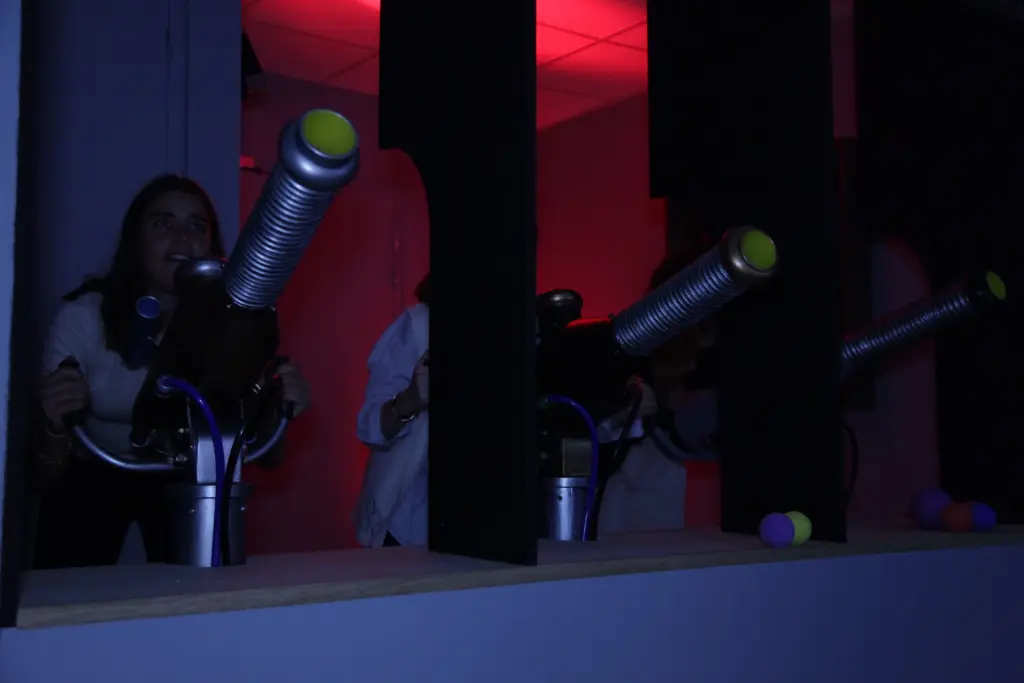 Personnes jouant avec des canons lumineux dans le noir.