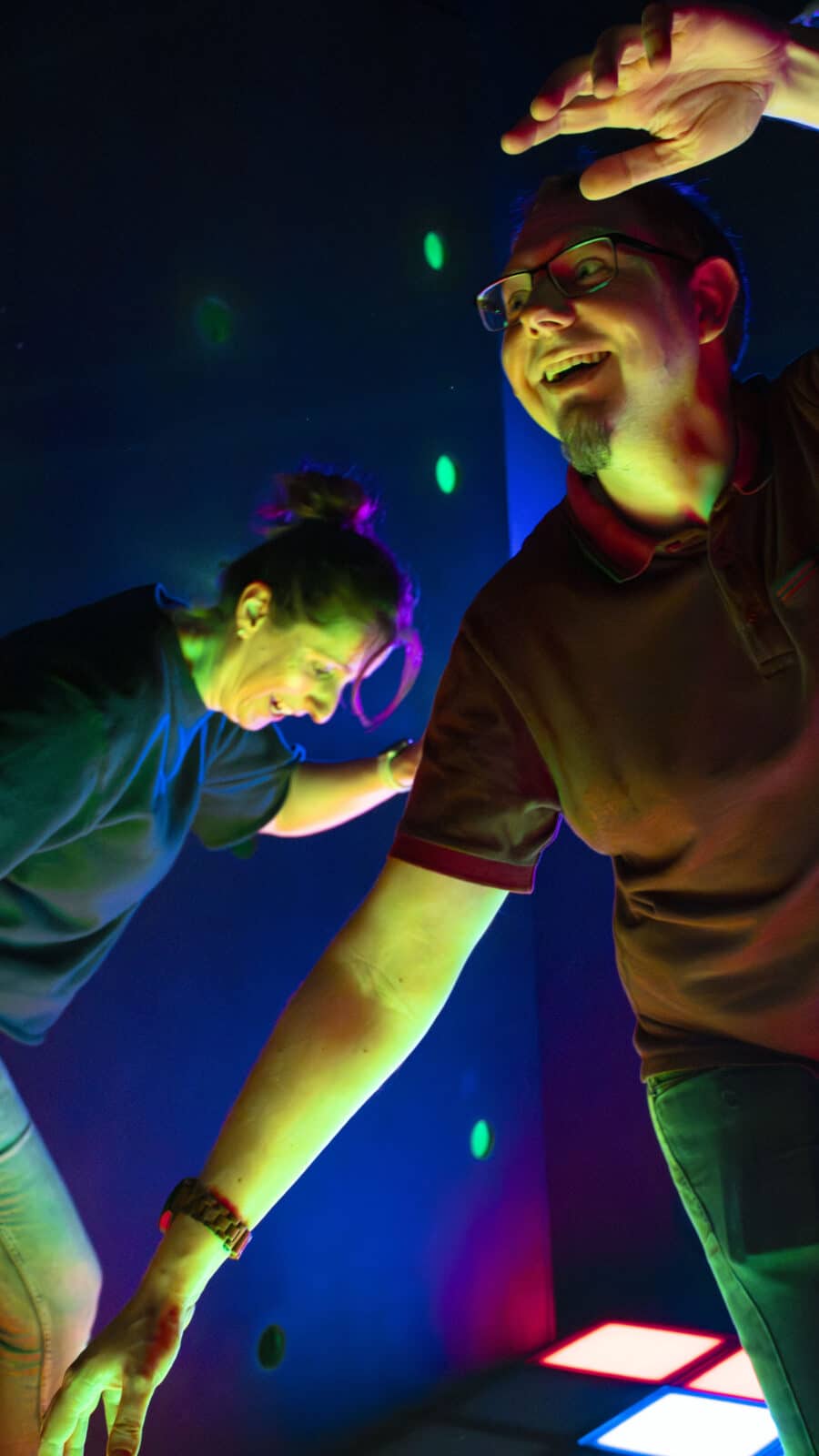 Deux personnes s'amusent sous des lumières colorées.