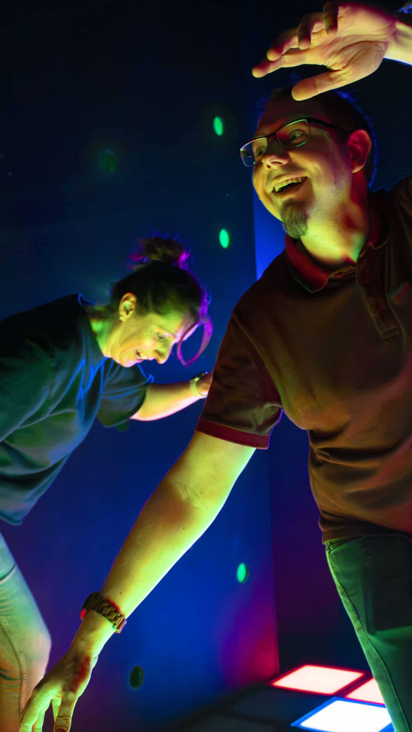 Deux personnes s'amusent sous des lumières colorées.