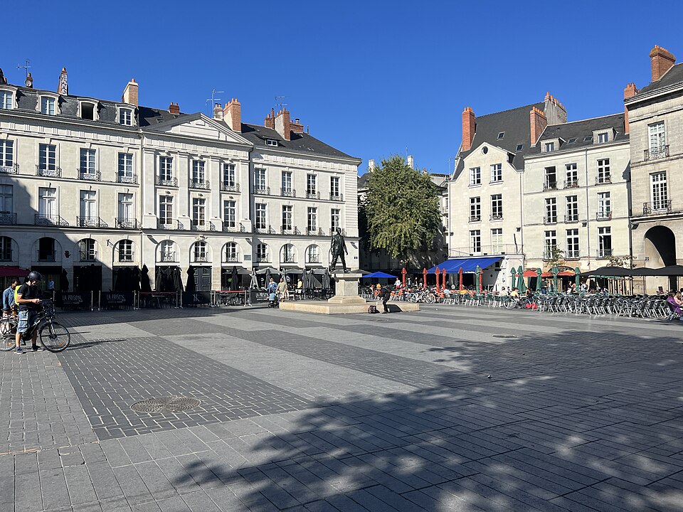 Place historique avec statue et terrasses ensoleillées