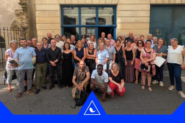 Groupe d’adultes posant devant un bâtiment