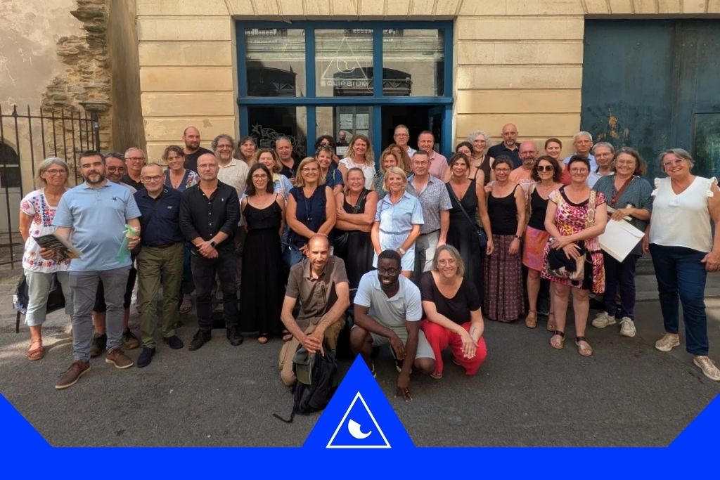 Groupe d’adultes posant devant un bâtiment